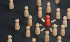 Czerwona figurka, symbol lidera z **mit charyzmy**, przyciąga uwagę innych. Złote strzałki wskazują na jej wpływ.