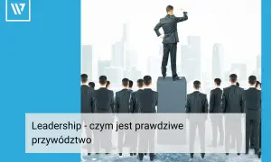 Mężczyzna na podwyższeniu, patrzący w dal, symbolizuje lidera. Grupa ludzi za nim pokazuje, że lider to ten, kto inspiruje i prowadzi innych.