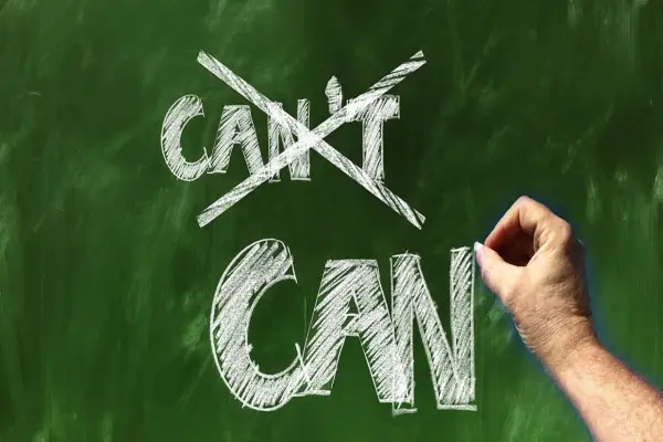 Ręka pisze kredą na tablicy "CAN", przekreślając "CAN'T". Koniec z postawą osoby pasywnej!